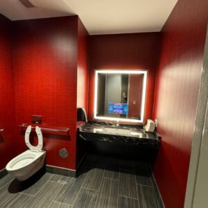 A bathroom with red walls and black trim.